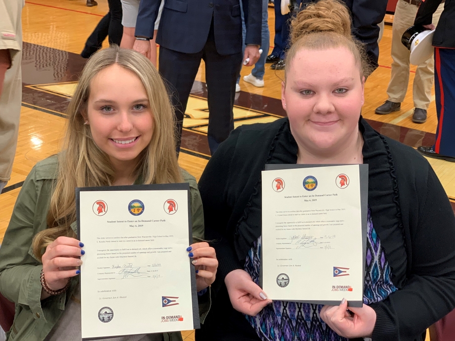 two girls holding certificates
